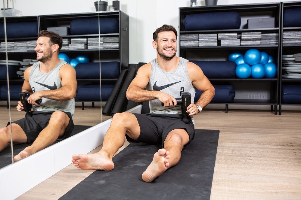 Power Plate MyoPro Massage Gun with ergonomic grip and multiple attachments for targeted muscle recovery and pain relief