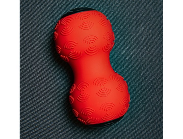 Power Plate DualSphere red textured massage tool shown from the side, highlighting contoured design for muscle recovery and pain relief