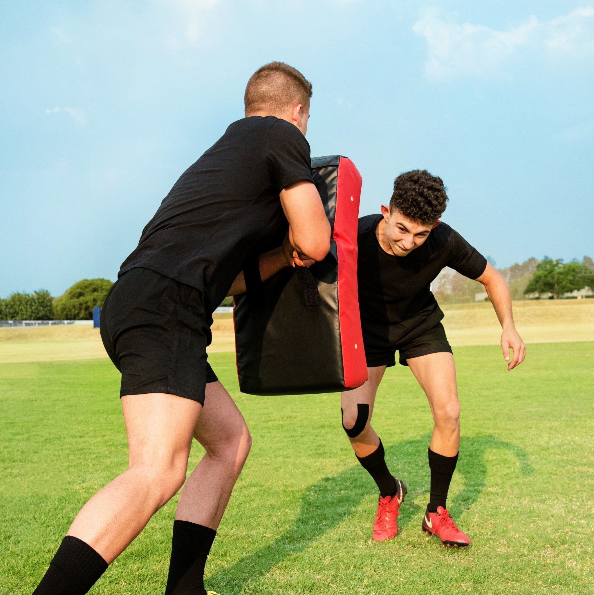 Ram Rugby Curve Hit Shield in black with orange accents, designed for rugby training, contact drills, and skill development